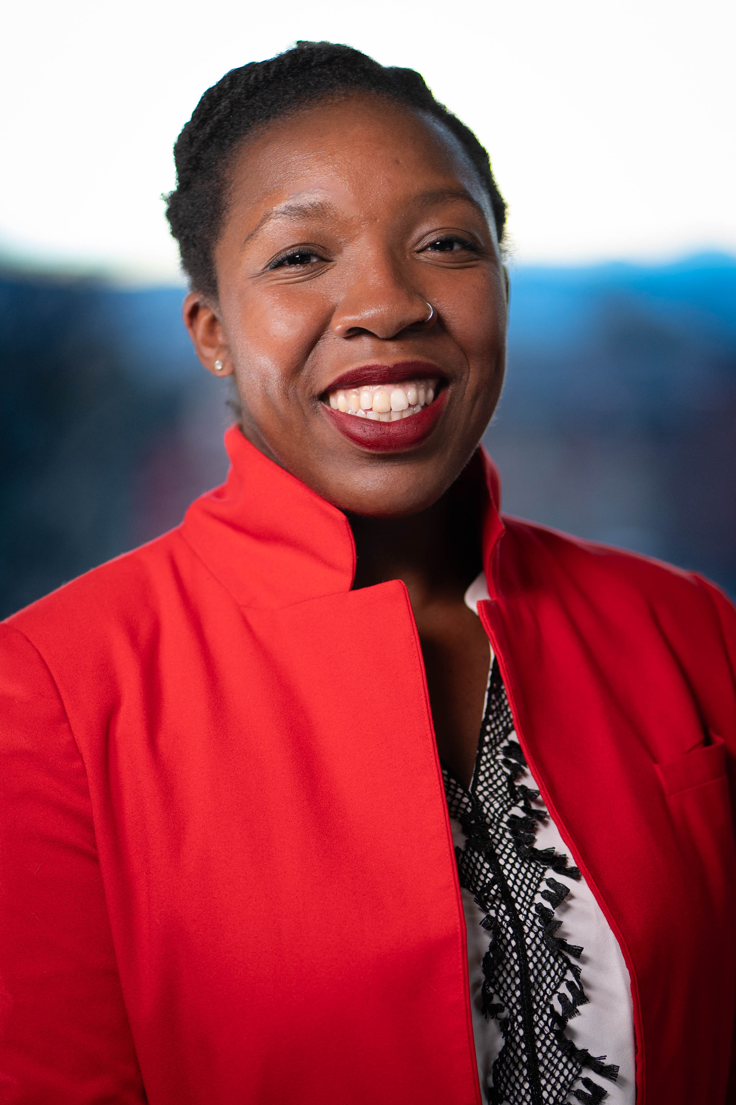 A woman looks at the camera and smiles.
