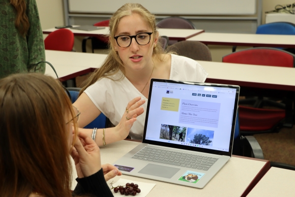 Student explaining something from a laptop