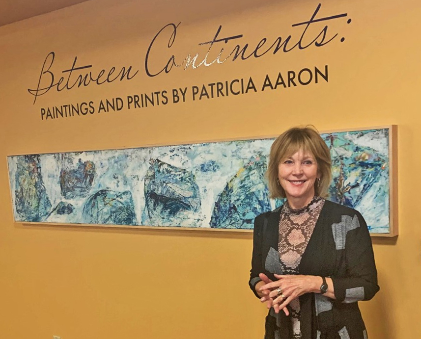 Patricia Aaron standing in front of the Between Continents exhibit.