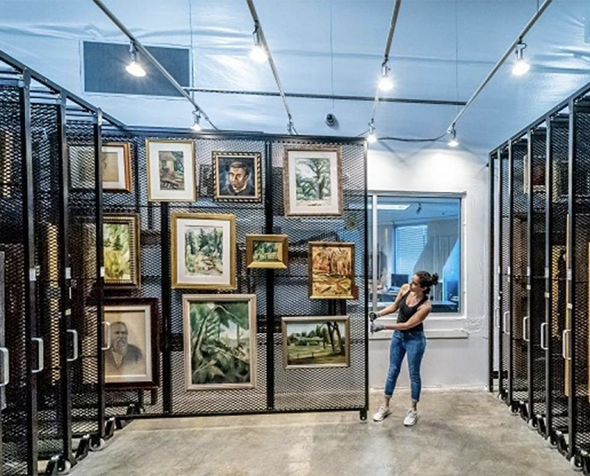 woman pulling out art stacks in university of denver art collections. 