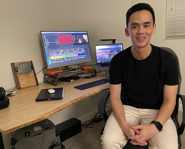 Lam Nguyen sits at his desk in front of his SXSW award plaque