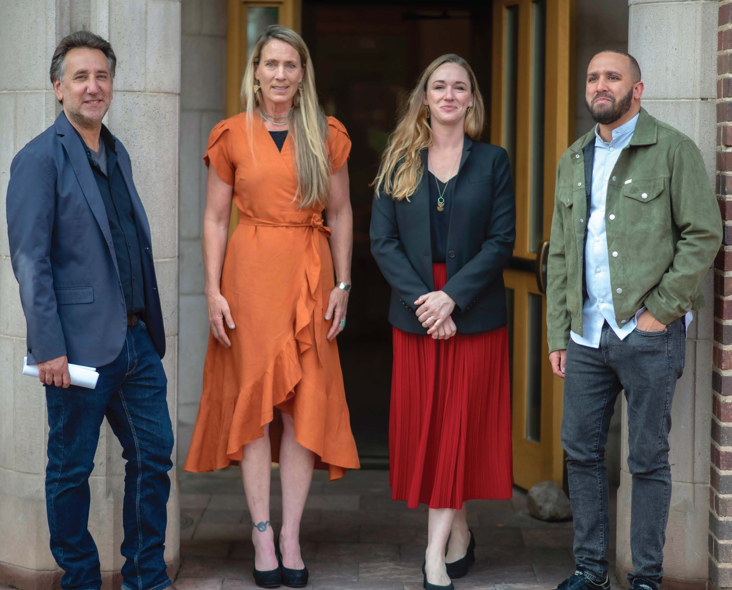 4 speakers for Journalism and Democracy Dialogue stand together in front of wooden doors