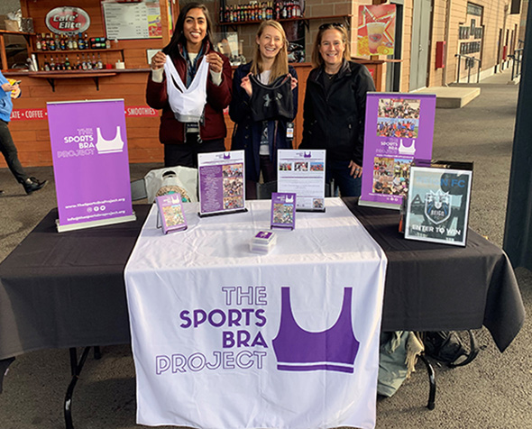 Members of The Sports Bra Project at holding up a bra at a drive.