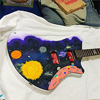 Cover art for Clog's "Night of the Worms" -- a photo of a guitar with the solar system painted on it.