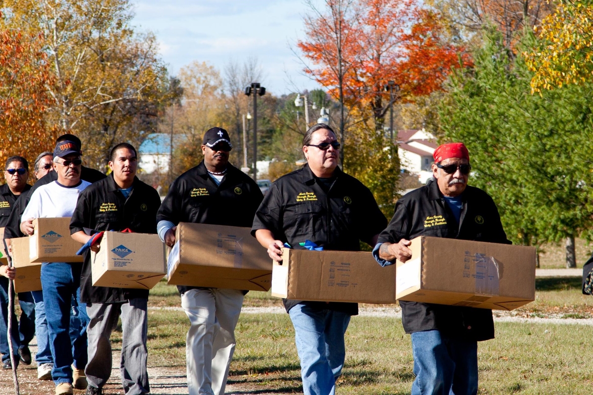 Line of people carrying cardboard boxes 