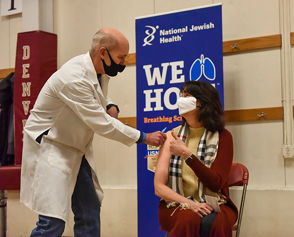 Doctor giving covid vaccine to patient