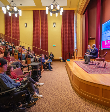 Lynn Clark and Jamelle Bouie sit on stage in conversation. The audience is visible on the left side