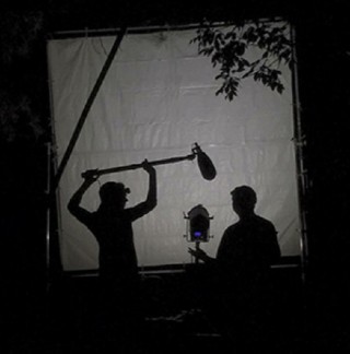 Silhouetted DU students operating film equipment