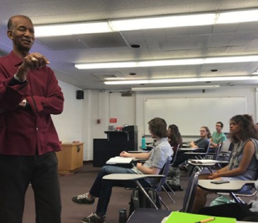 Moses Brewer speaking in front of a class