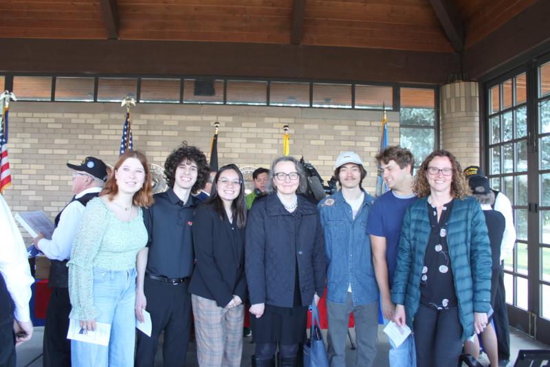 two professors with group of students at ceremony
