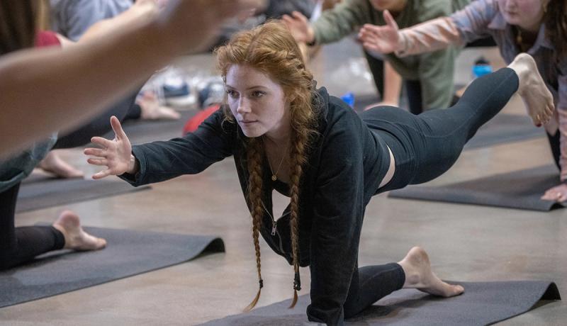 A student performs a yoga position at the Kennedy Mountain Campus.