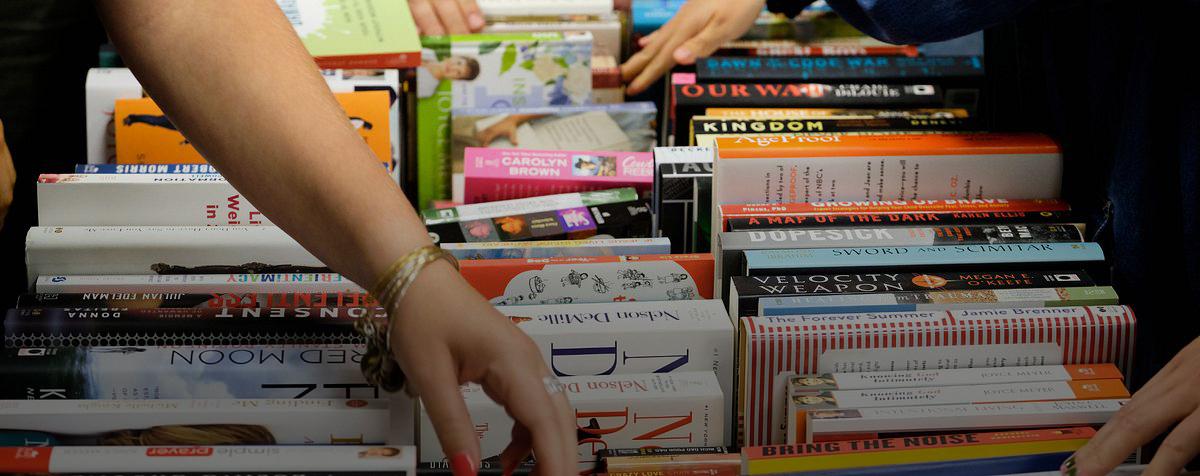 Students browse books at a DPI session.