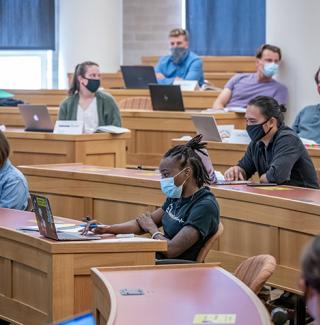 Law students wearing masks sit in a socially distanced classroom in 2020