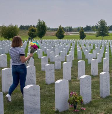 photo of cemetery with person carrying flowers