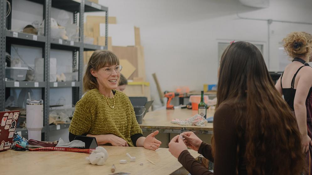 two women conversing in workshop