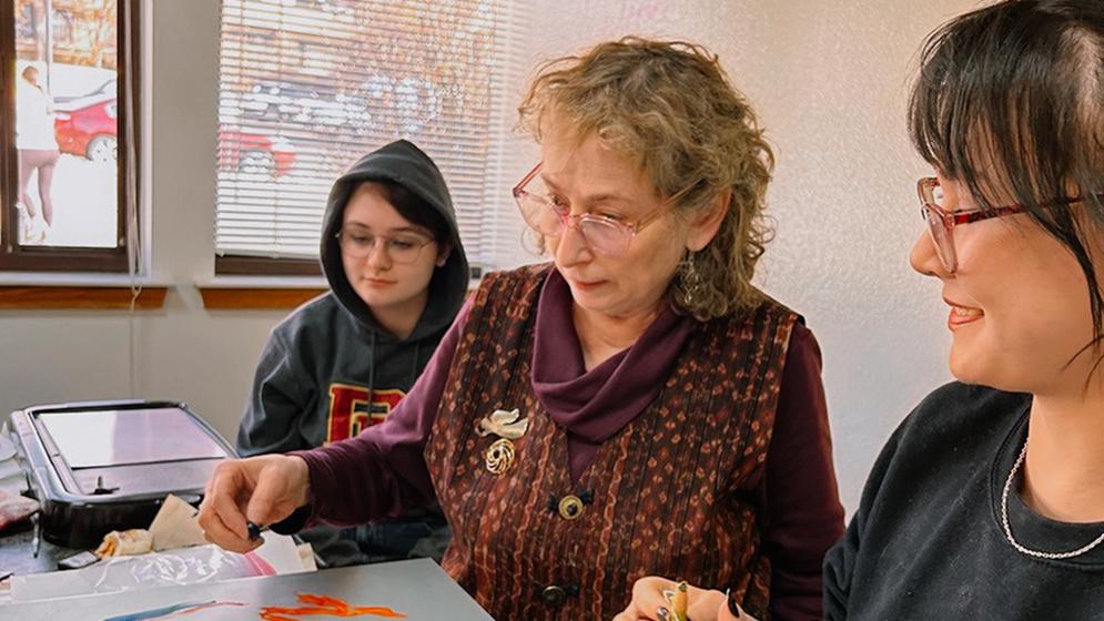 two students watching professor demonstrate