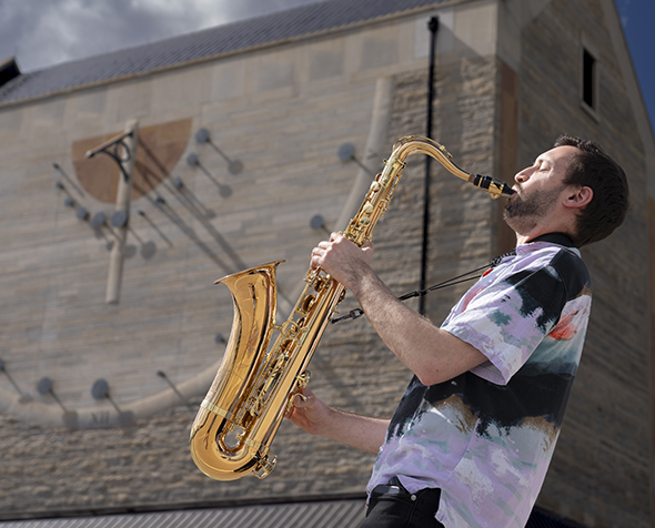 Adam Gang plays the saxophone.