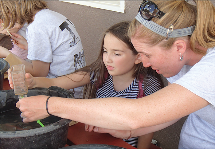 Washing finds during a community open house at the museum. Courtesy of the DU Amache Project.
